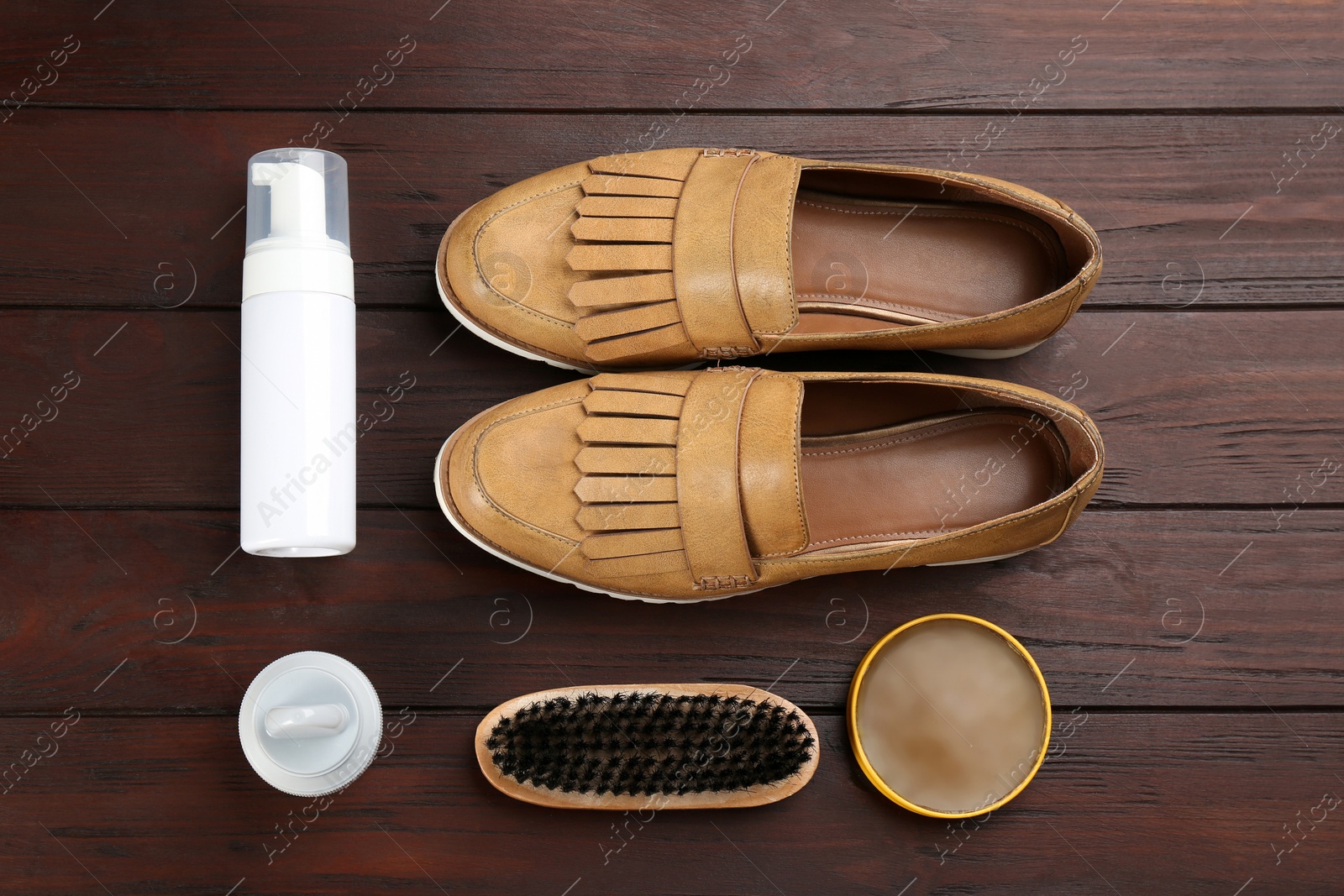 Photo of Flat lay composition with shoe care accessories and footwear on brown wooden background