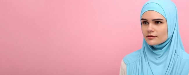 Portrait of Muslim woman in hijab on pink background, space for text. Banner design