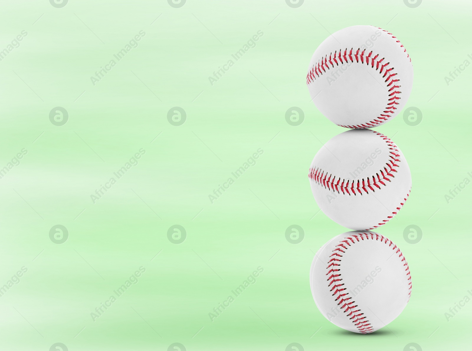 Image of Stack of baseball balls on light green background. Space for text