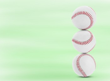 Image of Stack of baseball balls on light green background. Space for text