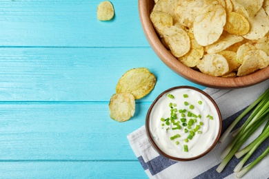 Sour cream and chips on blue wooden table, flat lay. Space for text