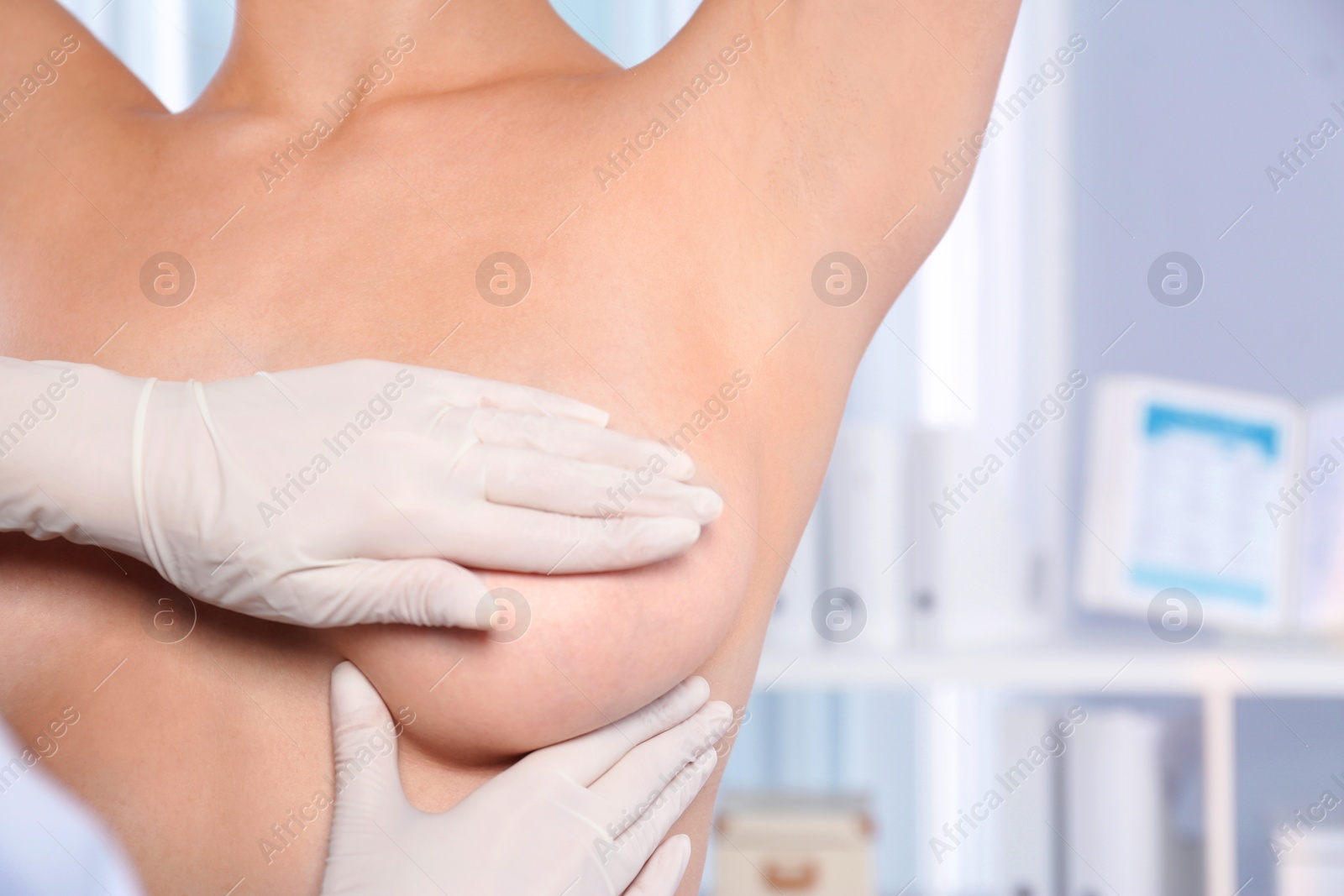 Photo of Doctor checking woman's breast at hospital, closeup