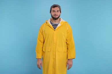 Photo of Fisherman in yellow raincoat on light blue background