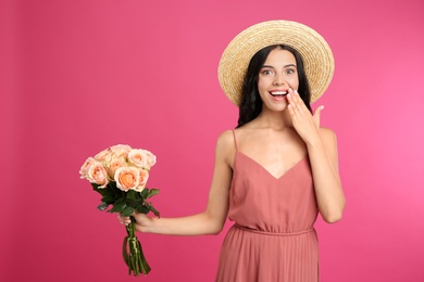 Portrait of emotional woman with beautiful bouquet on pink background
