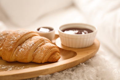 Photo of Delicious croissant and jam on tray, closeup. Delicious morning meal