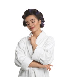 Photo of Happy young woman in bathrobe with hair curlers on white background