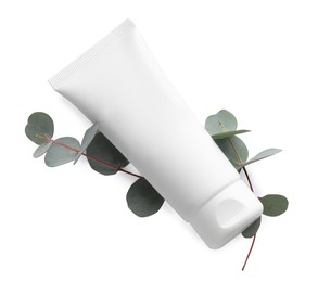 Tube of hand cream and eucalyptus on white background, top view
