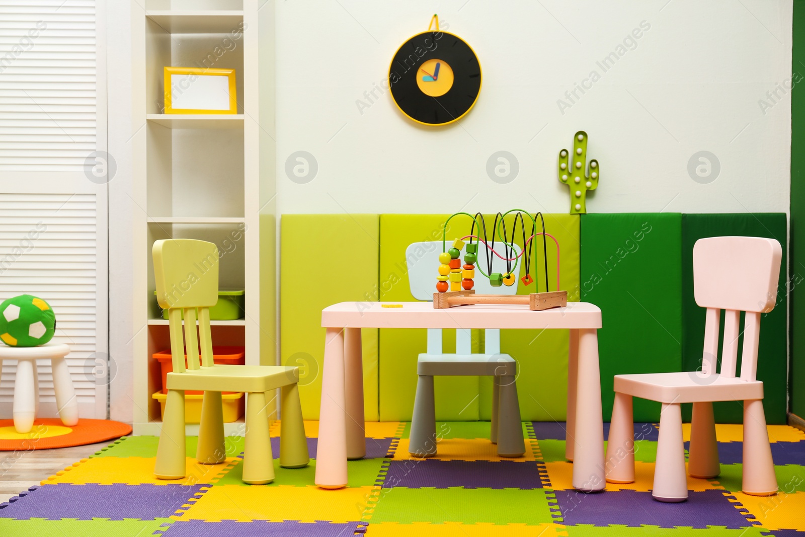 Photo of Stylish playroom interior with table and chairs