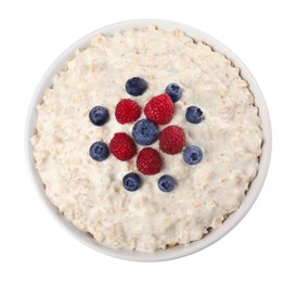 Photo of Tasty boiled oatmeal with berries in bowl isolated on white, top view