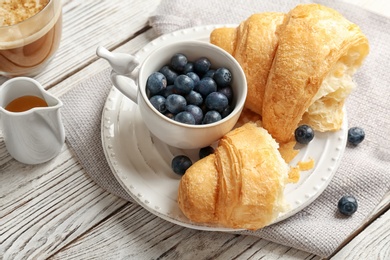 Tasty croissant with berries on plate