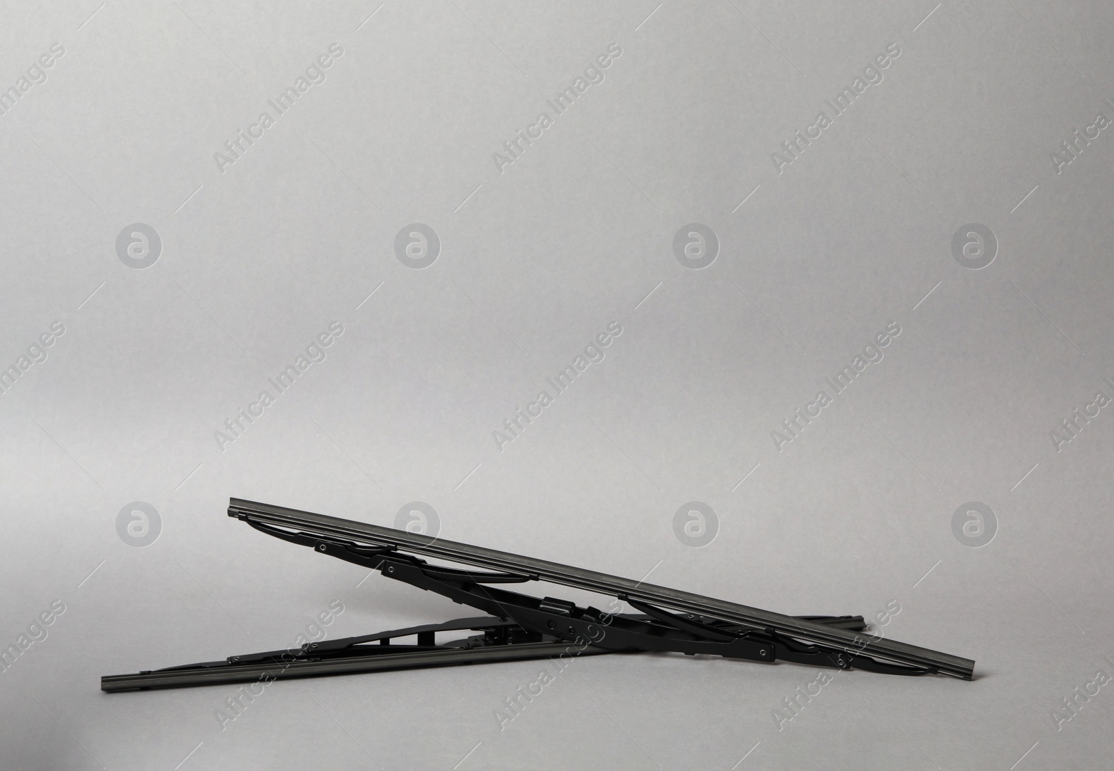 Photo of Car windshield wipers on grey background. Space for text
