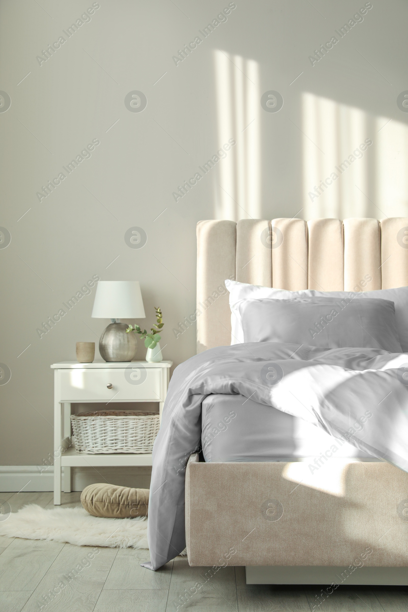 Photo of Bed with stylish silky linens in room