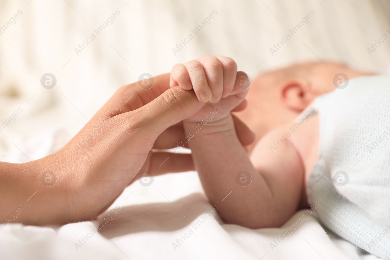 Photo of Mother and her newborn baby on bed, closeup