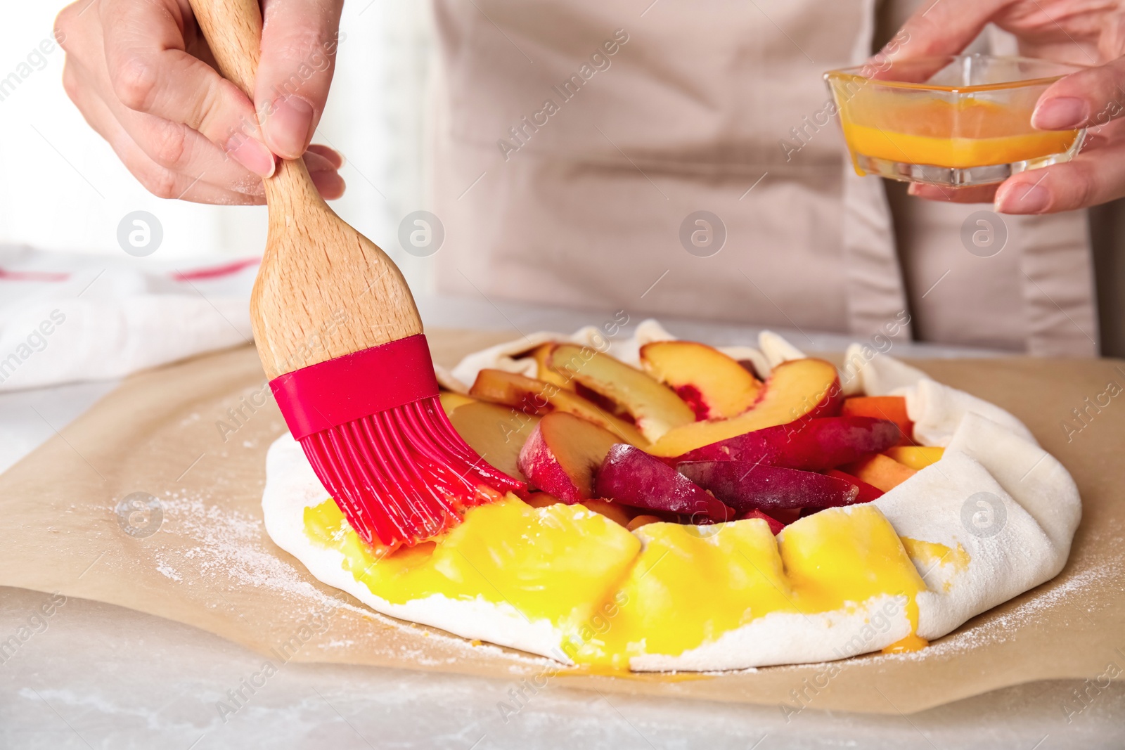 Photo of Woman making peach pie at kitchen table, closeup