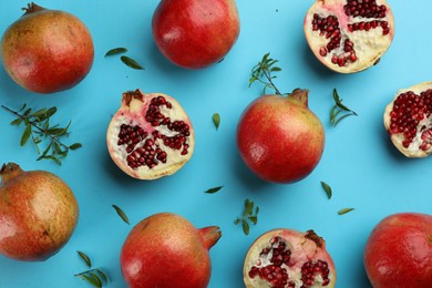 Photo of Flat lay composition with ripe pomegranates on light blue background