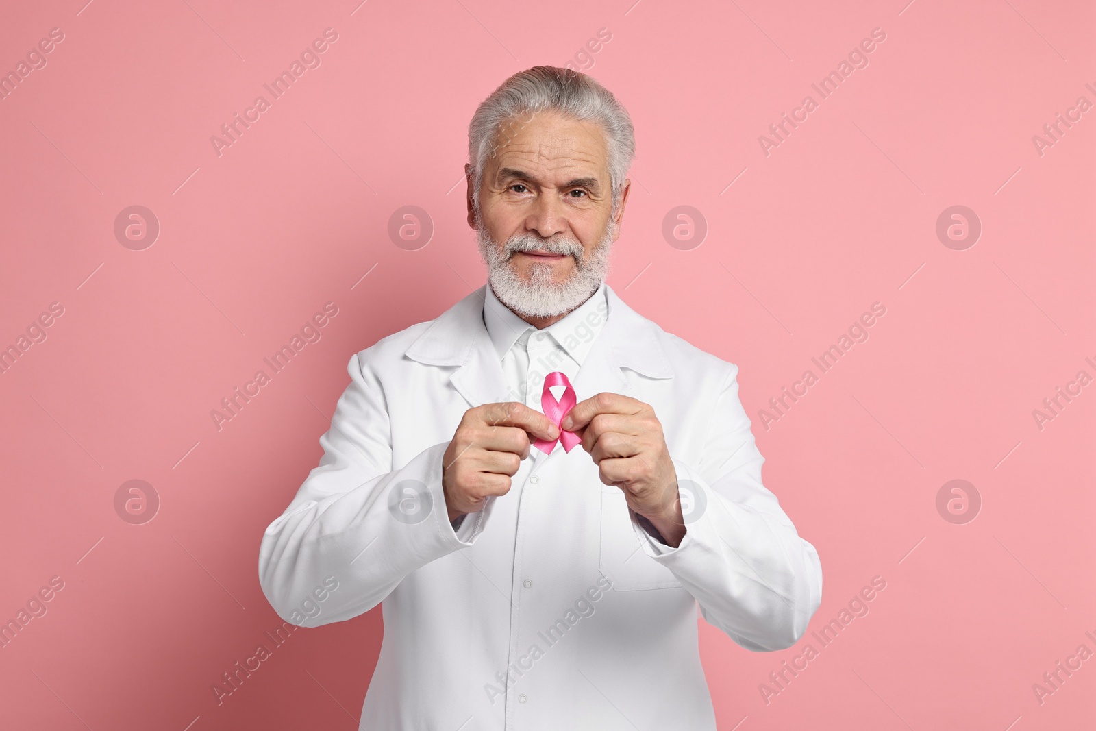 Photo of Mammologist with pink ribbon on color background. Breast cancer awareness