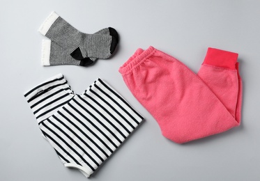 Flat lay composition with cute child clothes on color background