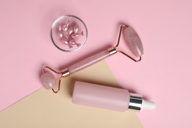 Photo of Face roller and skin care products on color background, flat lay