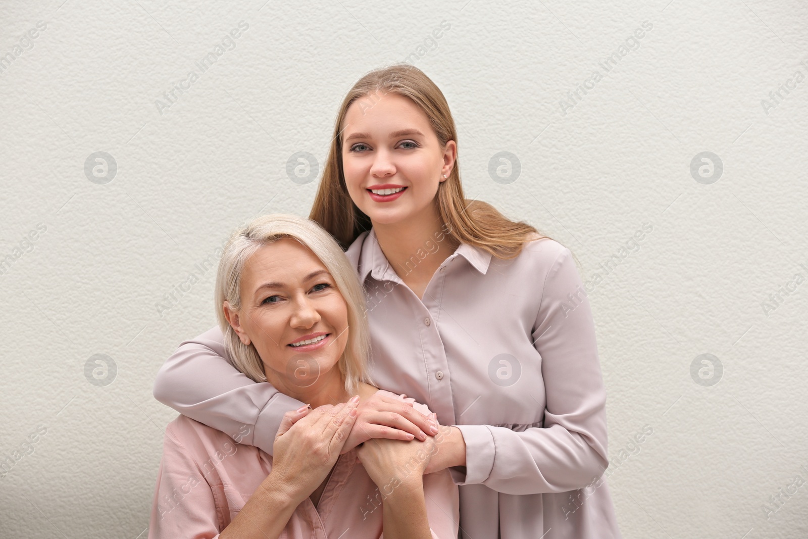 Photo of Mother and her adult daughter on white background