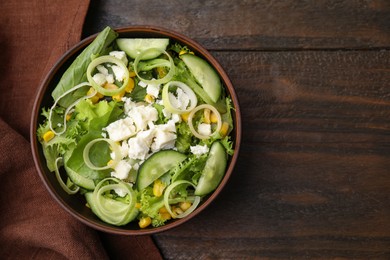 Photo of Bowl of tasty salad with leek and cheese on wooden table, top view. Space for text