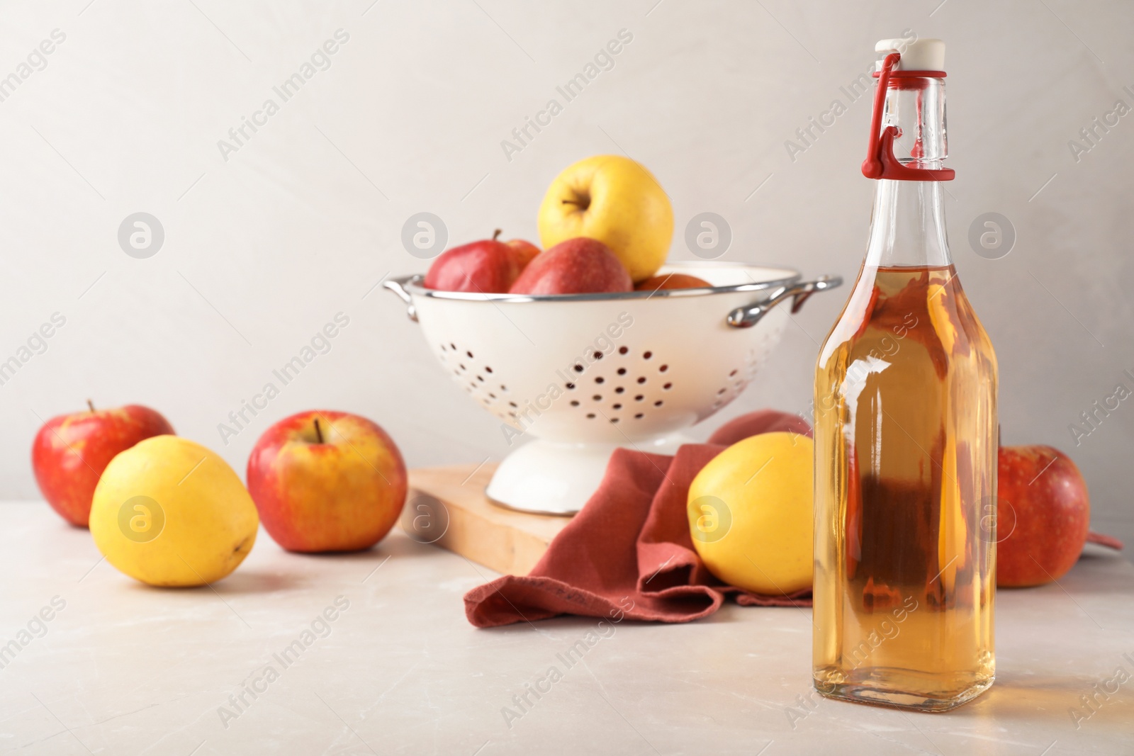 Photo of Composition with bottle of apple vinegar on table. Space for text