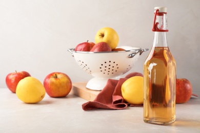 Photo of Composition with bottle of apple vinegar on table. Space for text