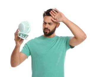Photo of Man with portable fan suffering from heat on white background. Summer season