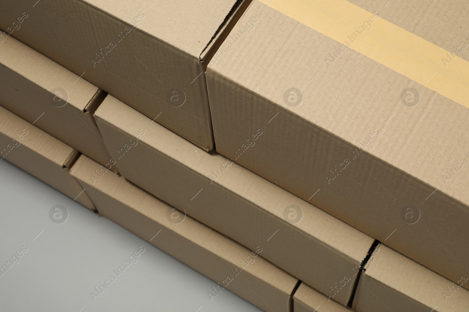 Photo of Stack of many closed cardboard boxes on light grey background, above view