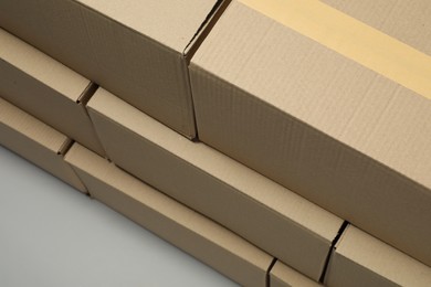 Photo of Stack of many closed cardboard boxes on light grey background, above view