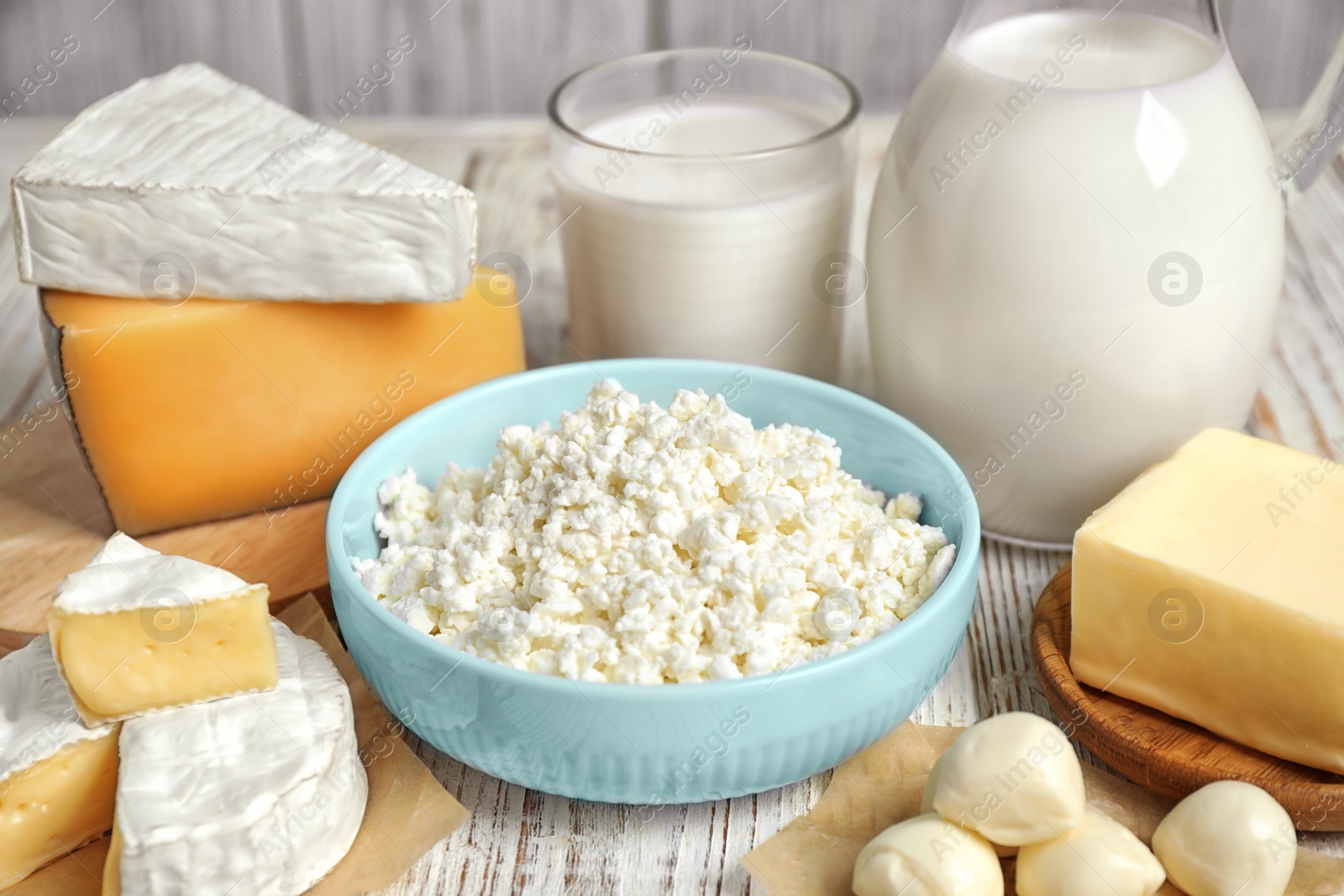 Photo of Different delicious dairy products on white wooden table