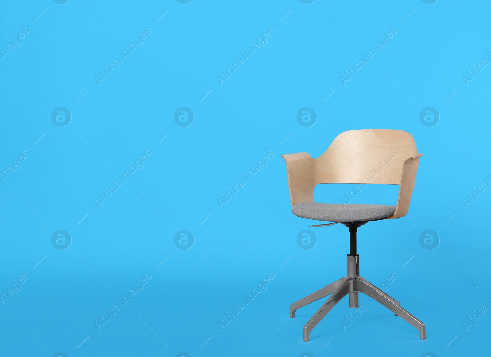 Photo of Comfortable office chair on light blue background, space for text