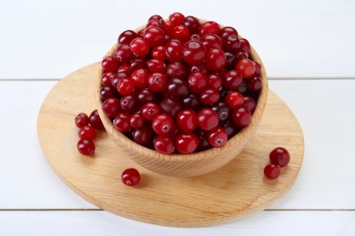 Photo of Fresh ripe cranberries in bowl on white wooden table, closeup