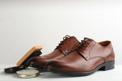Photo of Shoe care products and footwear on white table
