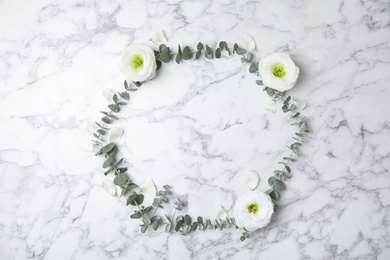 Photo of Fresh eucalyptus leaves with flowers and space for design on marble background, flat lay