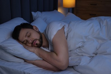 Handsome man sleeping in bed at night