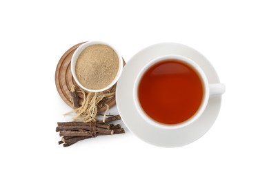 Photo of Aromatic licorice tea in cup, dried sticks of licorice root and powder isolated on white, top view