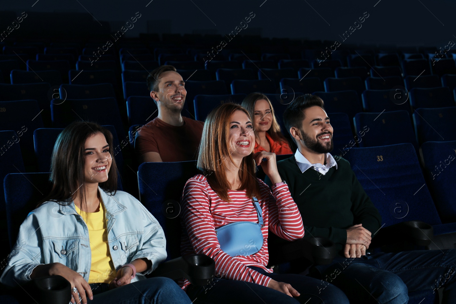 Photo of Young people watching movie in cinema theatre