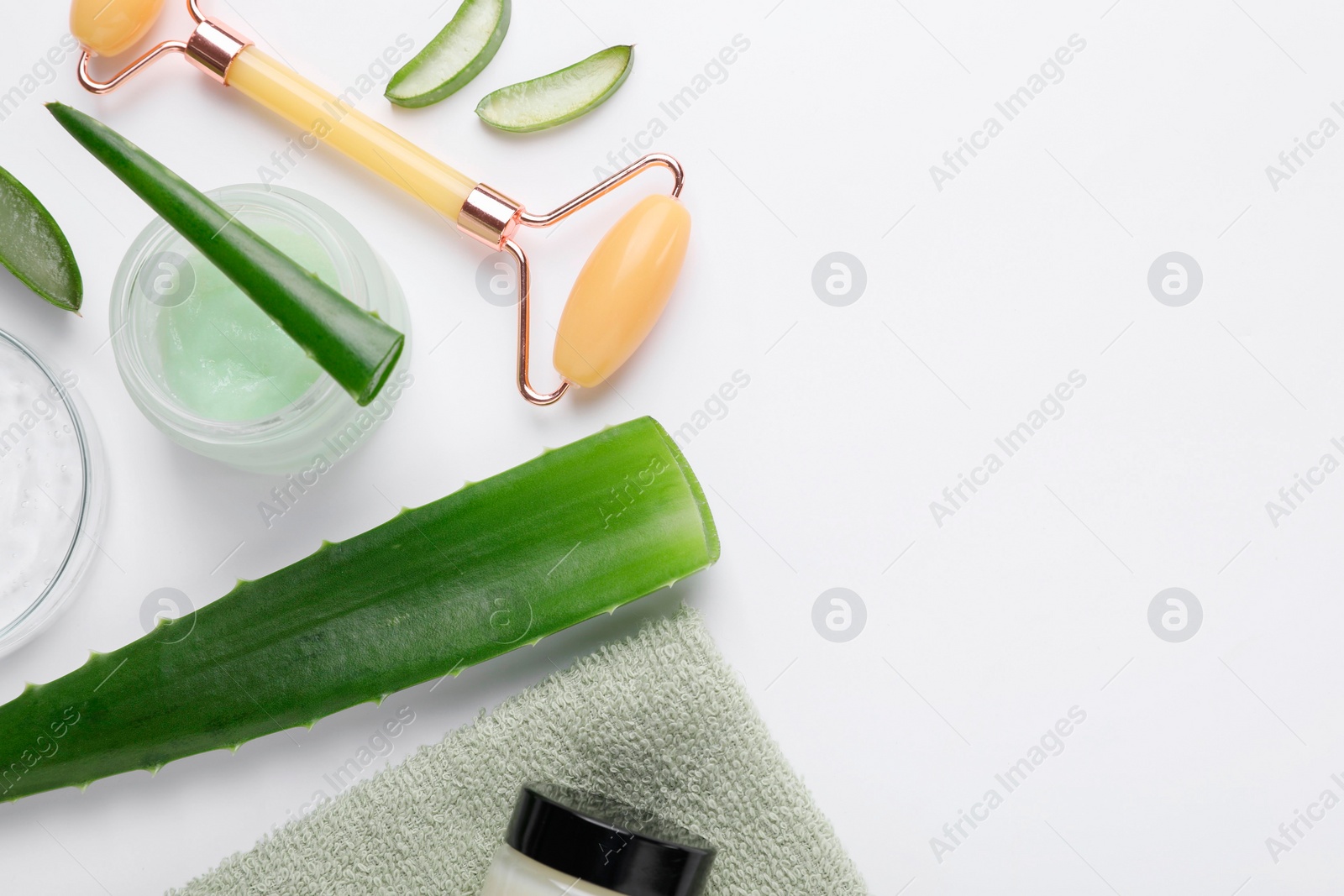 Photo of Flat lay composition with cosmetic products and cut aloe leaves on white background. Space for text