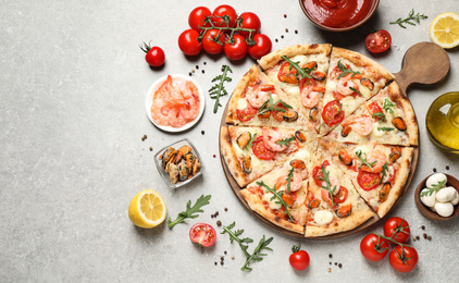 Photo of Delicious seafood pizza and fresh ingredients on light grey table, flat lay