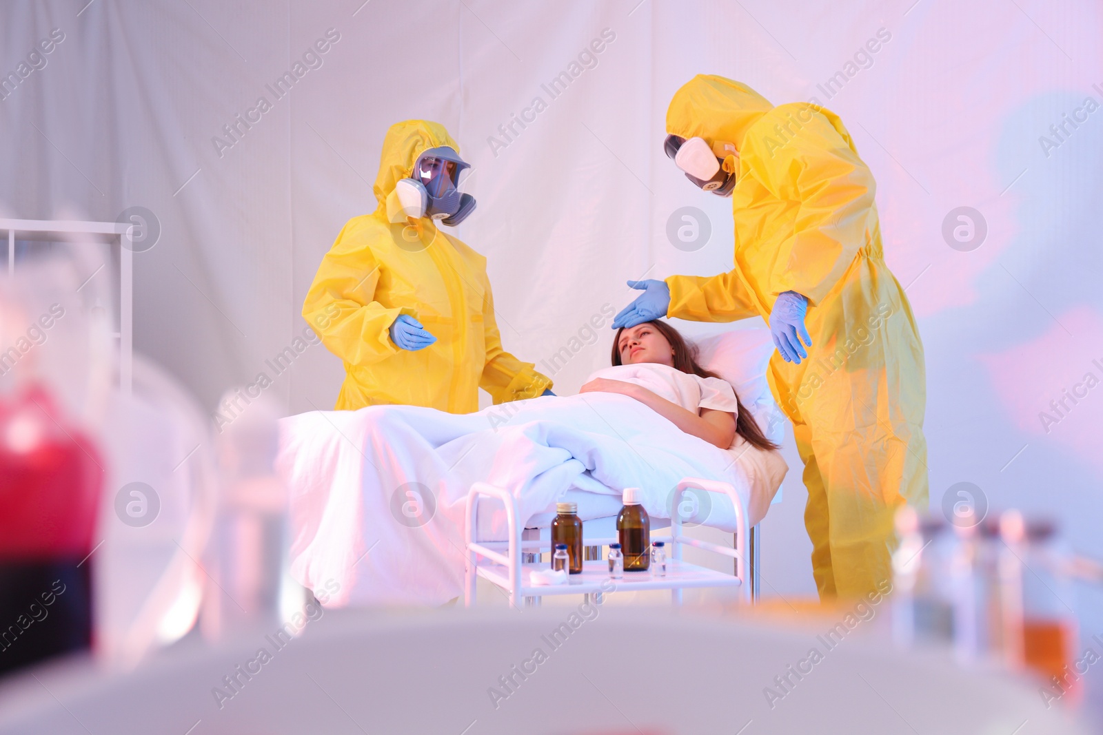 Photo of Professional paramedics examining patient with virus in quarantine ward