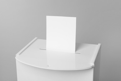 Ballot box with vote on light grey background, closeup. Election time
