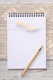 Photo of Guest list. Notebook, pen, spikelets and lace ribbon on wooden background, flat lay