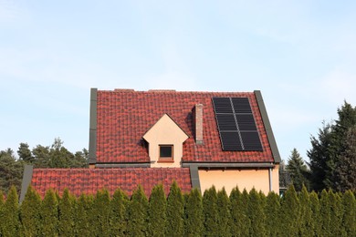 Photo of House with installed solar panels on roof. Alternative energy