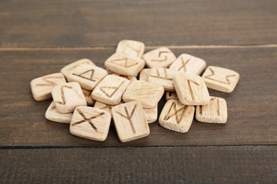 Photo of Pile of runes with different symbols on wooden table