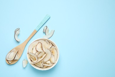 Flat lay composition with tasty coconut chips on light blue background. Space for text
