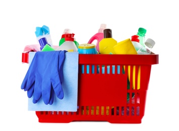 Photo of Shopping basket with different detergents, rag and gloves on white background