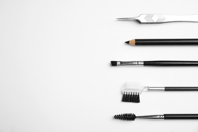 Photo of Set of professional eyebrow tools on white background, flat lay. Space for text