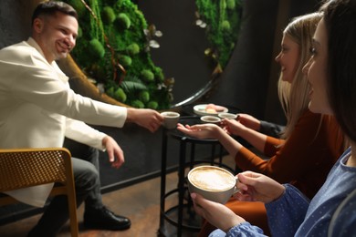 Photo of People with coffee spending time together in cafe