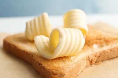 Photo of Toasted bread with fresh butter curls, closeup
