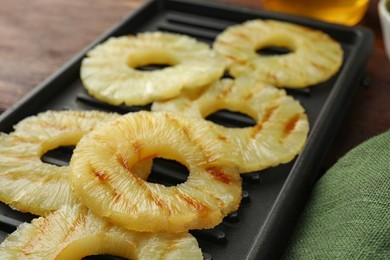 Photo of Tasty grilled pineapple slices on table, closeup
